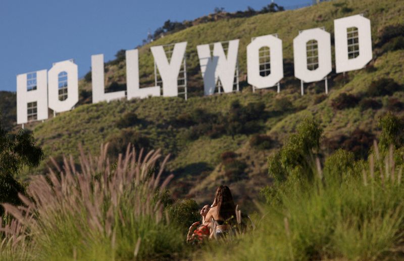 &copy; Reuters. Une femme pose devant le panneau d'Hollywood, à Los Angeles, Californie. /Photo prise le 9 octobre 2023/REUTERS/Mario Anzuoni