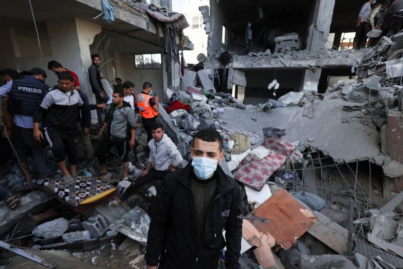 &copy; Reuters. FOTO DE ARCHIVO: Un grupo de palestinos busca víctimas en el lugar de un ataque israelí contra una casa en Ráfah, en medio del conflicto en curso entre Israel y el grupo islamista palestino Hamás, en el sur de la Franja de Gaza, 23 de noviembre 2023. 