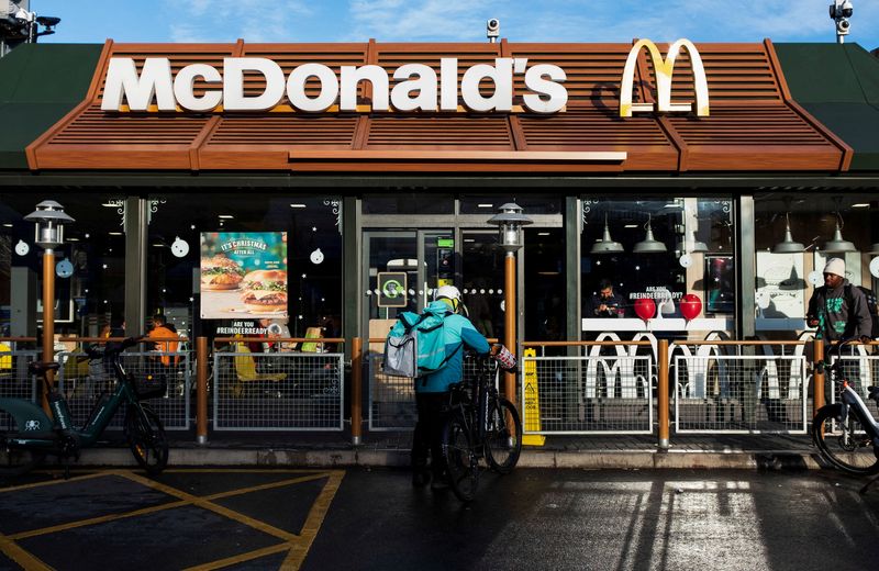 &copy; Reuters. FILE PHOTO: A Deliveroo rider stands beside a bicycle outside a McDonald's restaurant in London, Britain, December 10, 2021. Picture taken December 10, 2021. REUTERS/May James/File Photo