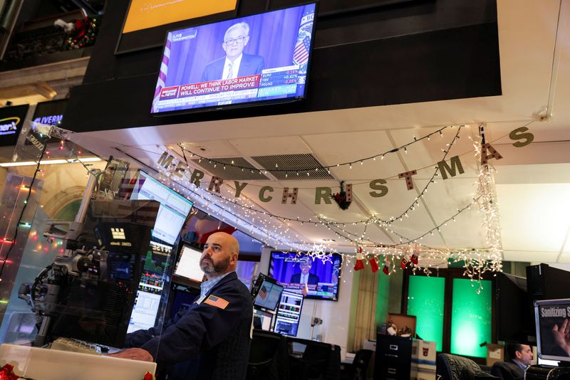 © Reuters. FILE PHOTO: Federal Reserve Chairman Jerome Powell is seen delivering remarks on screens as traders work on the trading floor at the New York Stock Exchange (NYSE) in Manhattan, New York City, U.S., December 15, 2021. REUTERS/Andrew Kelly/File Photo