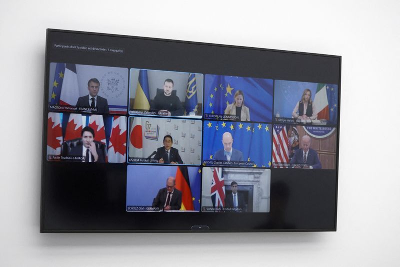 &copy; Reuters. I leader del Vertice appaiono su uno schermo televisivo durante una videoconferenza con il Presidente francese Emmanuel Macron, all'Eliseo di Parigi, Francia, 6 dicembre 2023.  YOAN VALAT/Pool via REUTERS