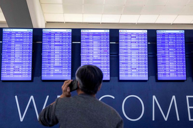 &copy; Reuters. FILE PHOTO: A passenger checks their flight status at Hartsfield-Jackson Atlanta International Airport after the Federal Aviation Administration (FAA) had ordered airlines to pause all domestic departures due to a system outage in Atlanta, Georgia, U.S., 