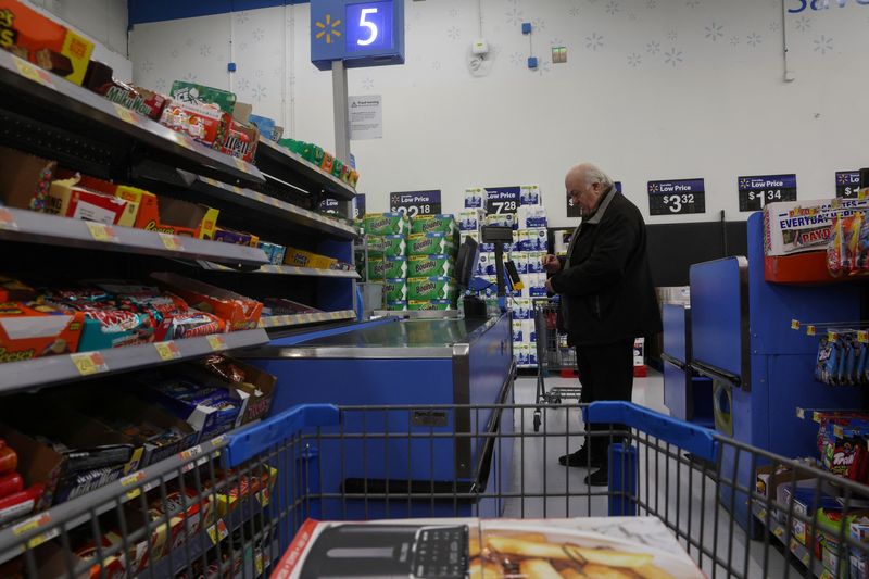 © Reuters. File photo: A man pays for a purchase at checkout inside a Walmart department store in Westbury, New York, U.S., November 15, 2023.  REUTERS/Shannon Stapleton/File photo