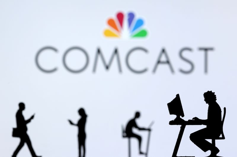 &copy; Reuters. Small toy figures with laptops and smartphones are seen in front of displayed Comcast logo, in this illustration taken December 5, 2021. REUTERS/Dado Ruvic/Illustration/File Photo