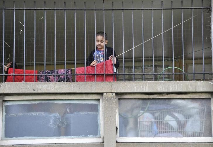 © Reuters. A child plays behind railings on the Robin Hood Gardens estate in Poplar, in East London, March 27, 2010.  REUTERS/Jas Lehal/files