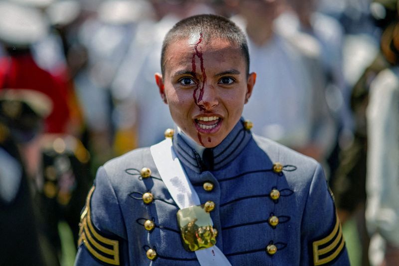 © Reuters. SENSITIVE MATERIAL. THIS IMAGE MAY OFFEND OR DISTURB         A just-graduated cadet bleeds after being hit by a hat tossed in the air, at the end of the 2023 graduation ceremony at the United States Military Academy (USMA) at West Point, New York, U.S., May 27, 2023. Photographer Eduardo Munoz was covering the May 2023 graduation ceremony at the Army's prestigious U.S. Military Academy in West Point, New York. He was taking pictures of that familiar moment when the graduates, resplendent in their gray and white dress uniforms, toss their hats into the air to celebrate their achievement. Amid the crowd, he spotted something different. 