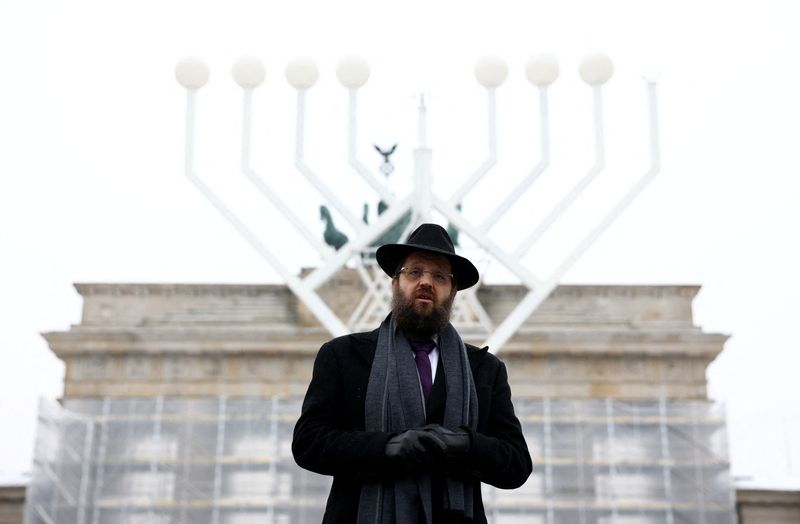 &copy; Reuters. El rabino Yehuda Teichtal posa junto a una menorá gigante instalada con motivo de la festividad judía de Janucá frente a la Puerta de Brandemburgo en Berlín, Alemania. 6 de diciembre, 2023. REUTERS/Liesa Johannssen