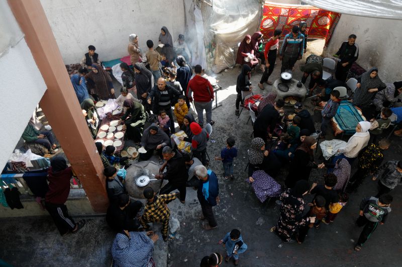 &copy; Reuters. Palestinos desplazados cocinan en una escuela que acoge a personas que huyeron de sus casas debido a los ataques israelíes, en Rafah, en el sur de la Franja de Gaza. 7 de diciembre de 2023. REUTERS/Saleh Salem