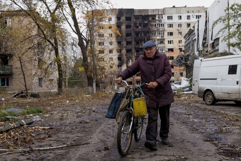 &copy; Reuters. FILE PHOTO: A local resident walks in front of damaged residential buildings, amid Russia's attack non Ukraine, in the town of Avdiivka, Donetsk region, Ukraine October 17, 2023. REUTERS/Yevhen Titov//File Photo