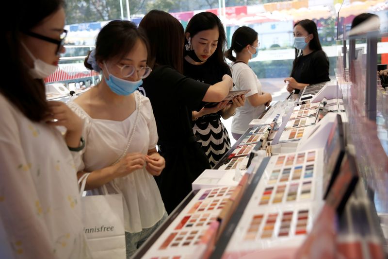 &copy; Reuters. FILE PHOTO: Customers wearing face masks shop at a Chinese cosmetics brand Perfect Diary store, following the coronavirus disease (COVID-19) outbreak  in Beijing, China August 25, 2020. REUTERS/Tingshu Wang/File Photo