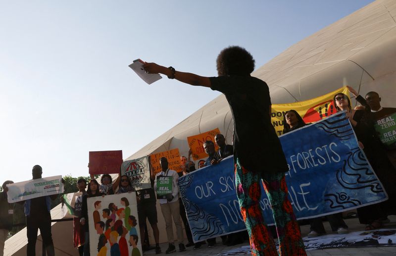 &copy; Reuters. Ativistas seguram cartazes e gritam slogans durante protesto na COP28 em Dubai
08/12/2023
REUTERS/Thaier Al-Sudani