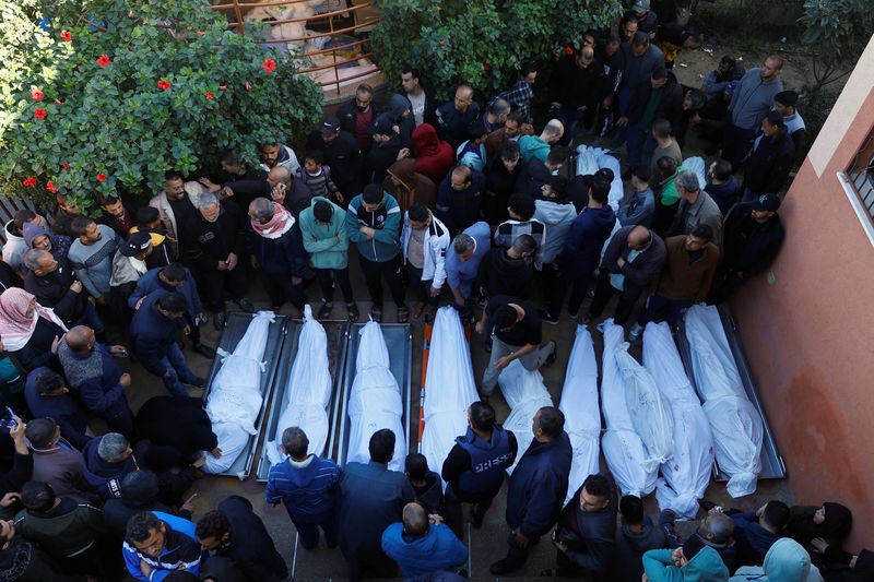 &copy; Reuters. Foto del sábado de un grupo de personas junto a los cadáveres de palestinos muertos en ataques israelíes, en medio del actual conflicto entre Israel y el grupo islamista palestino Hamás, durante un funeral en el hospital Nasser de Jan Yunis, en el sur