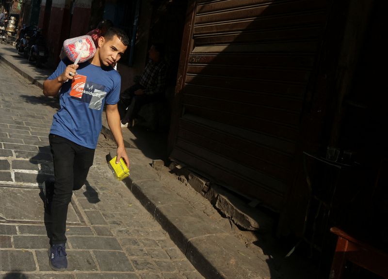 &copy; Reuters. رجل يحمل على ظهره أكياس السكر المدعم من بين السلع التموينية المدعمة في إحدى الحارات بحي الجمالية بالقاهرة في الرابع من ديسمبر كانون الأول 202
