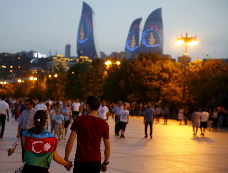 © Reuters. A girl, draped in Azerbaijan's national flag, walks with a boy on a street in downtown Baku, Azerbaijan June 18, 2015.  REUTERS/Stoyan Nenov/File Photo