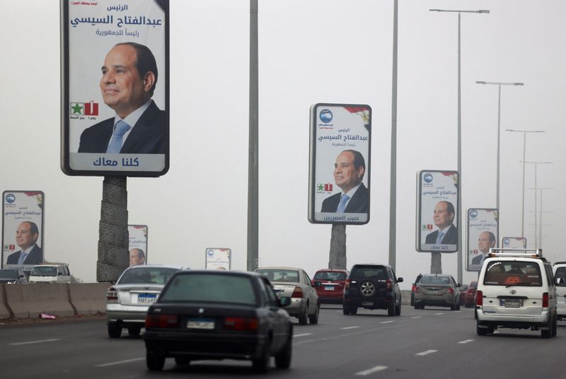 &copy; Reuters. سيارات تمر أمام لافتات للرئيس المصري عبد الفتاح السيسي في القاهرة يوم الخامس من ديسمبر كانون الأول 2023. تصوير: محمد عبد الغني - رويترز.

