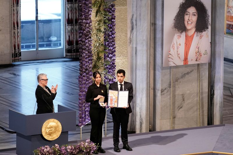 © Reuters. Ali and Kiana Rahmani, children of Narges Mohammadi, an imprisoned Iranian human rights activist, hold the Nobel Peace Prize 2023 award, accepting it on behalf of their mother at Oslo City Hall, Norway December 10, 2023. NTB/Fredrik Varfjell via REUTERS 