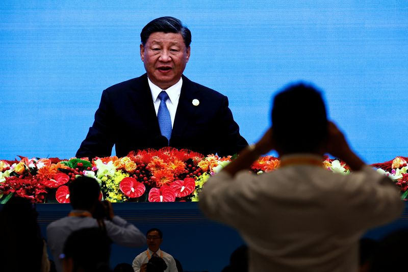 &copy; Reuters. FILE PHOTO: Journalists watch a giant screen broadcasting footage of Chinese President Xi Jinping speaking at the opening ceremony of the Third Belt and Road Forum (BRF), at the media centre in Beijing, October 18, 2023. REUTERS/Tingshu Wang/FILE PHOTO