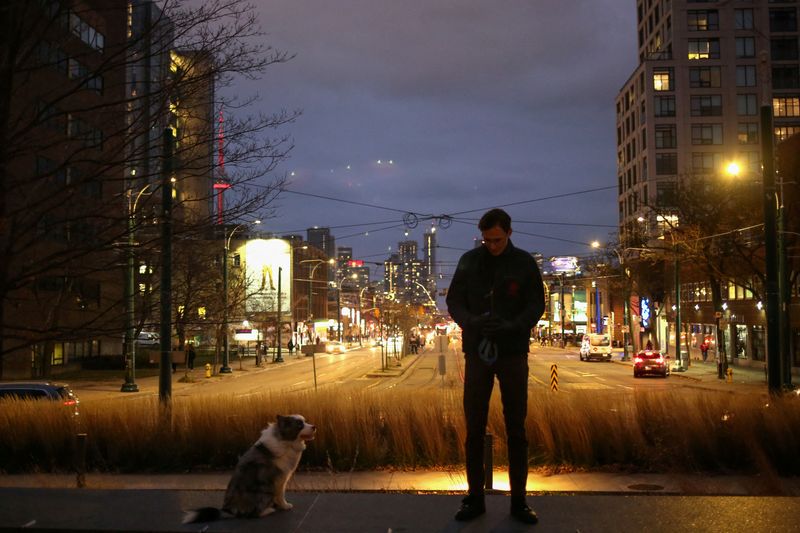 &copy; Reuters.   １２月９日、成功を夢見てカナダにやってきた多くの移民が、生計の維持に苦しんでいる。写真は飼い犬を散歩させるリトアニア出身のジャスティナス・スタンカスさん。トロントで１１