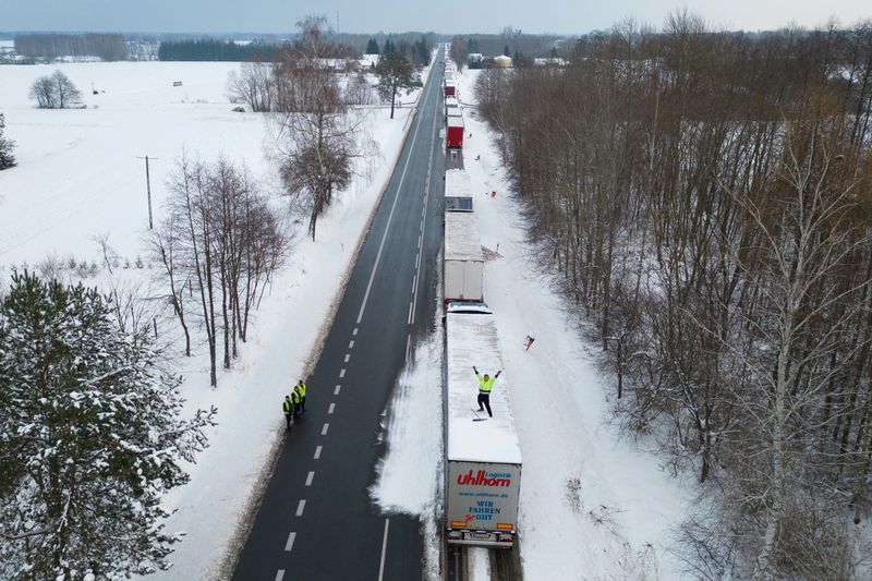 &copy; Reuters. FILE PHOTO: A truck driver from Ukraine waves from his truck roof while waiting in a long queue to cross the Polish-Ukrainian border at the Dorohusk-Jagodzin crossing, in Okopy, Poland, December 4, 2023. REUTERS/Kuba Stezycki/File Photo