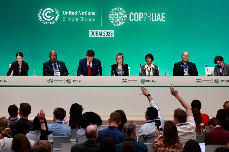 &copy; Reuters. Des personnes lèvent la main pendant une conférence de presse, lors de la Conférence des Nations Unies sur le changement climatique (COP28), à Dubaï. /Photo prise le 11 décembre 2023/REUTERS/Thaier Al-Sudani