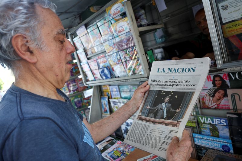 &copy; Reuters. Homem lê jornal um dia depois de Javier Milei assumir Presidência da Argentina
11/12/2023. REUTERS/Agustin Marcarian