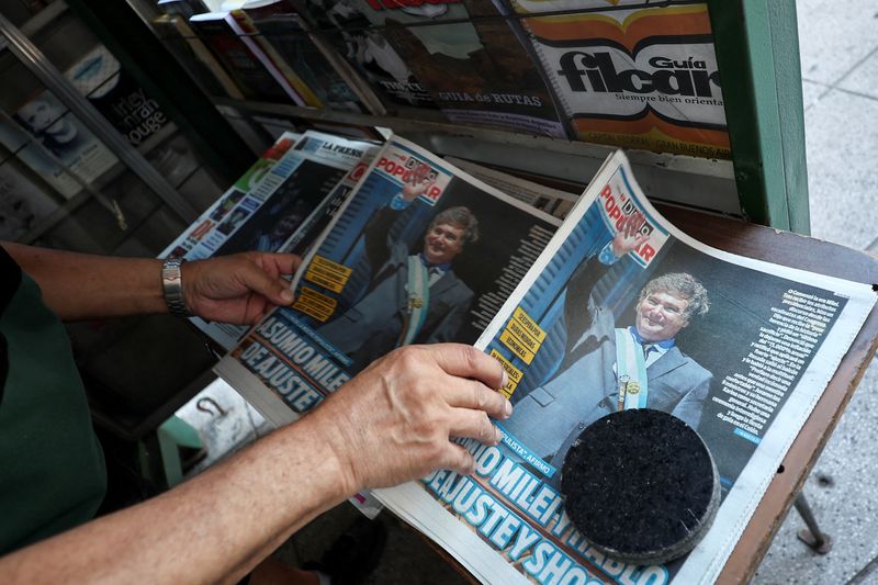 &copy; Reuters. A kiosk owner rearranges newspapers, one day after the inauguration of Argentina's President Javier Milei and his Vice President Victoria Villarruel, in Buenos Aires, Argentina, December 11, 2023. REUTERS/Agustin Marcarian