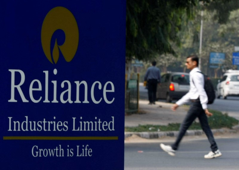 &copy; Reuters. FILE PHOTO: A man walks past a Reliance Industries Limited sign board installed on a road divider in the western Indian city of Gandhinagar, January 17, 2014. REUTERS/Amit Dave/File Photo
