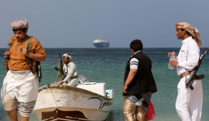 &copy; Reuters. FOTO DE ARCHIVO: Hombres armados en la playa mientras el buque comercial Galaxy Leader, incautado por los hutíes de Yemen el mes pasado, está anclado frente a la costa de al-Salif, Yemen. 5 de diciembre de 2023. REUTERS/Khaled Abdullah