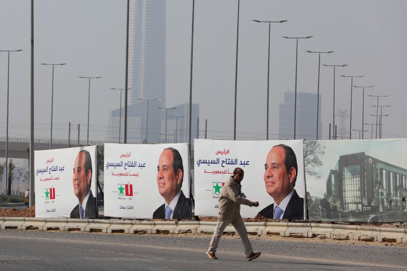 &copy; Reuters. Homem caminha perto de cartazes do candidato à reeleição do presidente do Egito, Abdel Fattah al-Sisi, ,na Nova Capital Administrativa, perto do Cairo
12/12/2023 REUTERS/Mohamed Abd El Ghany