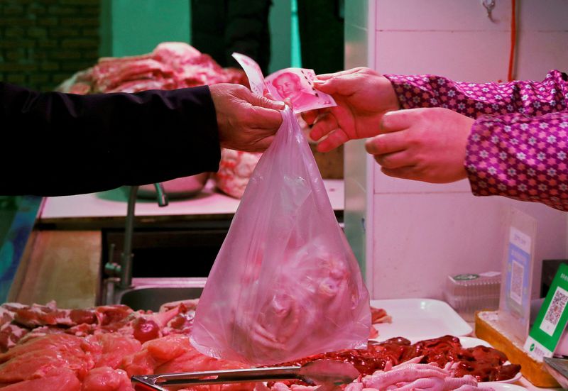 &copy; Reuters. FILE PHOTO: A man pays for meat at a market in Beijing, China January 11, 2021. REUTERS/Tingshu Wang/File Photo