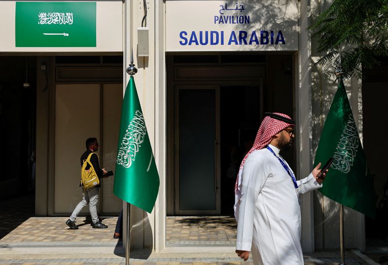 &copy; Reuters. Imagen de archivo de personas pasando junto al pabellón de Arabia Saudita en la conferencia climática COP28 en Dubái, EAU. 6 diciembre 2023. REUTERS/Thaier Al-Sudani