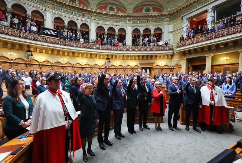 &copy; Reuters. Federal Councillors Viola Amherd, Guy Parmelin, Ignazio Cassis, Karin Keller-Sutter, Albert Roesti, Elisabeth Baume-Schneider, Beat Jans and Chancellor Viktor Rossi swear after the ministerial elections at the Swiss Parliament in Bern, Switzerland, Decemb