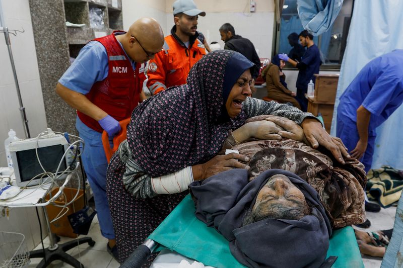 &copy; Reuters. امرأة فلسطينية تبكي بجوار رجل مصاب في مستشفى ناصر في أعقاب الغارات الإسرائيلية في خان يونس بجنوب قطاع غزة في التاسع من ديسمبر كانون الأول 2023