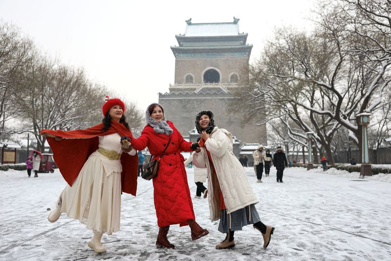 &copy; Reuters. Mulheres posam para foto em rua coberta de neve em Pequim
13/12/2023
REUTERS/Tingshu Wang