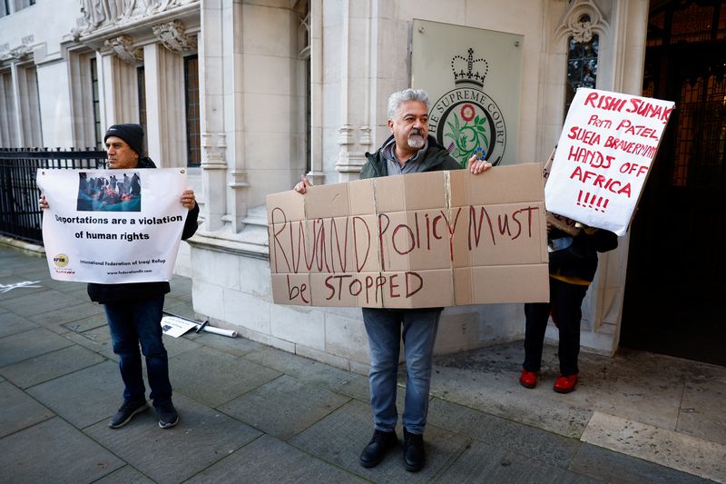 &copy; Reuters. Protestors hold placards outside of the Supreme Court, on the day the Supreme Court delivers its ruling on whether the government can go ahead with its plan to deport migrants to Rwanda, in London, Britain, November 15, 2023. REUTERS/Peter Nicholls/File P
