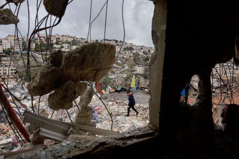 &copy; Reuters. Palestino caminha por casa destruída em meio a conflito entre Israel e o grupo Hamas
13/12/2023 REUTERS/Ammar Awad