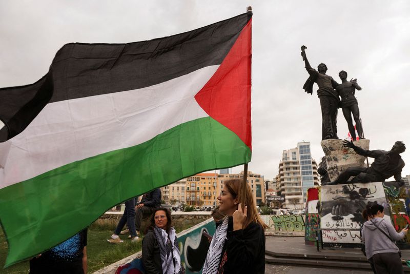 &copy; Reuters. A demonstrator holds a Palestinian flag during a sit-in, in response to the global call for strike in solidarity with Gaza and Palestinian people, at Martyrs' Square, downtown Beirut, Lebanon, December 11, 2023. REUTERS/Mohamed Azakir
