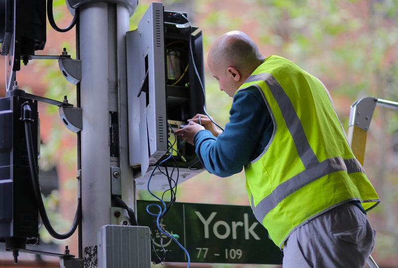 © Reuters. FILE PHOTO: A worker adjusts the electrical wiring of traffic lights in central Sydney, Australia, June 16, 2017. Picture taken June 16, 2017.     REUTERS/Steven Saphore/File Photo