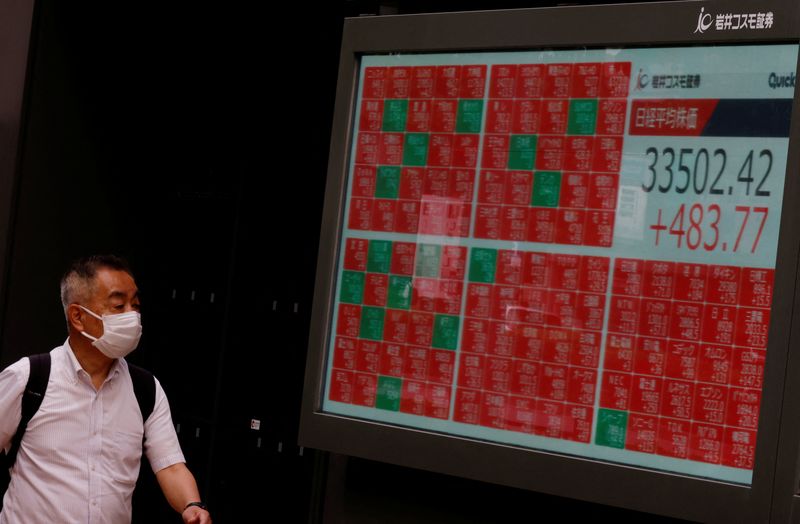 &copy; Reuters. رجل ينظر إلى لوحة إلكترونية تعرض بيانات مؤشر نيكي الياباني خارج شركة للوساطة المالية في طوكيو يوم 14 يونيو حزيران 2023. تصوير: كيم كيونج هون - رو