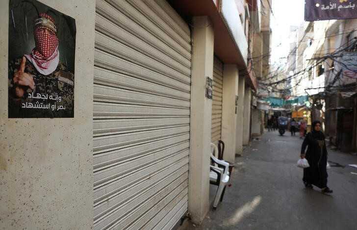 © Reuters. A woman walks past shops closed in response to the global call for a strike in solidarity with Gaza and Palestinian people, at Burj al-Barajneh refugee camp in Beirut, Lebanon December 11, 2023. REUTERS/Mohamed Azakir