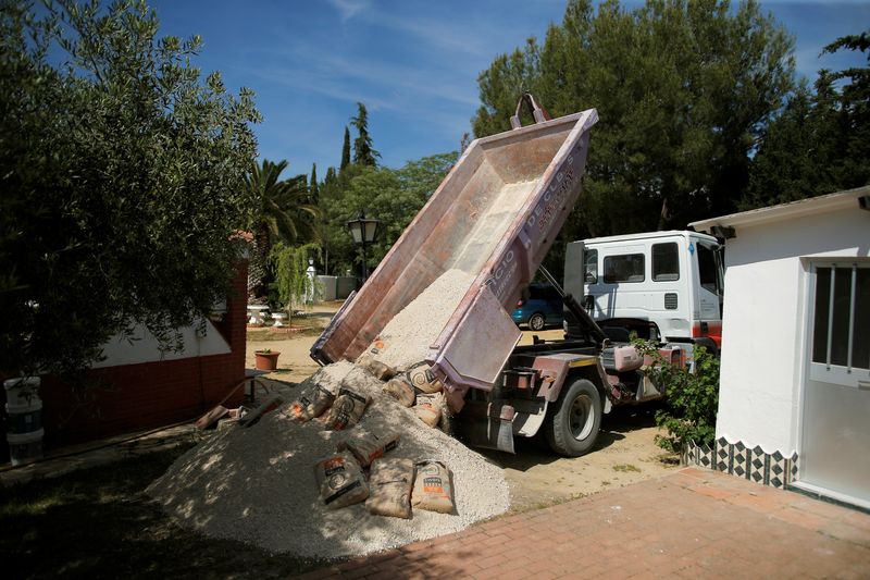 &copy; Reuters. FOTO DE ARCHIVO: Un camionero descarga sacos de arena y cemento de un remolque en casa de un cliente en Ronda, España. 7 de junio de 2018. Foto tomada el 7 de junio de 2018. REUTERS/Jon Nazca