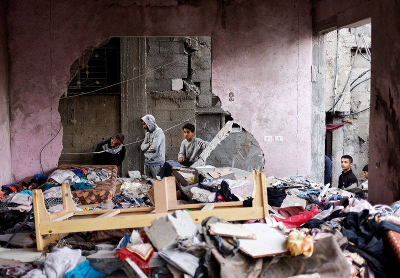 © Reuters. Palestinos inspeccionan el lugar de los ataques israelíes contra viviendas, en medio del actual conflicto entre Israel y el grupo islamista palestino Hamás, en Rafah, en el sur de la Franja de Gaza. 14 de diciembre de 2023. REUTERS/Mohammed Salem 