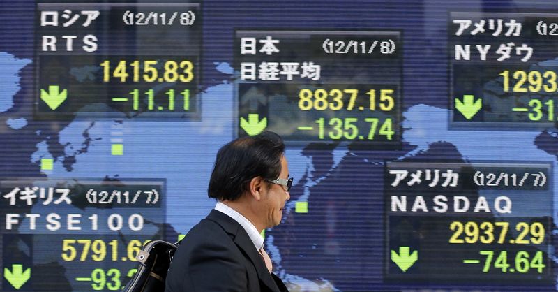 &copy; Reuters. A man passes an electronic board displaying falls in global market indices outside a brokerage in Tokyo November 8, 2012. REUTERS/Yuriko Nakao/file photo