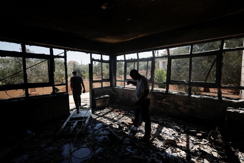 © Reuters. فلسطينيون في مبنى محترق جراء هجوم مستوطنين إسرائيليين قرب رام الله بالضفة الغربية المحتلة يوم 21 يونيو حزيران 2023. تصوير: محمد تركمان - رويترز.