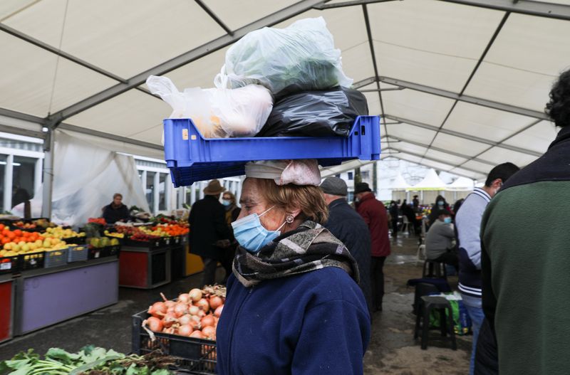 &copy; Reuters. FILE PHOTO: A seller carries products at the market during a lockdown following a surge of coronavirus disease (COVID-19) cases, in Vila Real, Portugal February 5, 2021. REUTERS/Violeta Santos Moura/File Photo