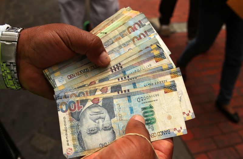 &copy; Reuters. FILE PHOTO: A money changer holds Peruvian Sol bills at a street in downtown Lima, Peru, December 15, 2017. REUTERS/Mariana Bazo