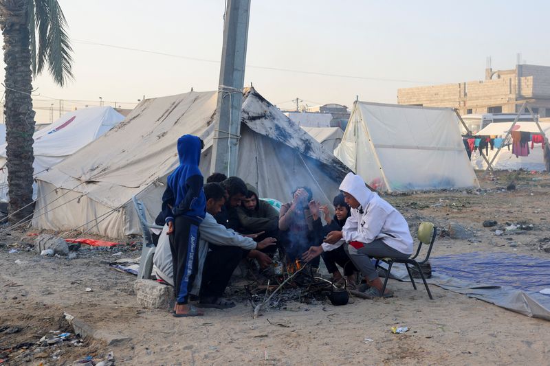 &copy; Reuters. نازحون فلسطينيون فروا من منازلهم بسبب الغارات الإسرائيلية يجلسون حول نار في مخيم يحتمون به في رفح بجنوب قطاع غزة يوم 12 ديسمبر كانون الأول 2023