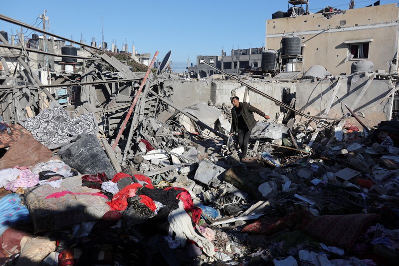 © Reuters. A Palestinian man walks on ruins at the site of an Israeli strike on a house, amid the ongoing conflict between Israel and the Palestinian Islamist group Hamas, in Rafah in the southern Gaza Strip, December 15, 2023. REUTERS/Ibraheem Abu Mustafa     TPX IMAGES OF THE DAY