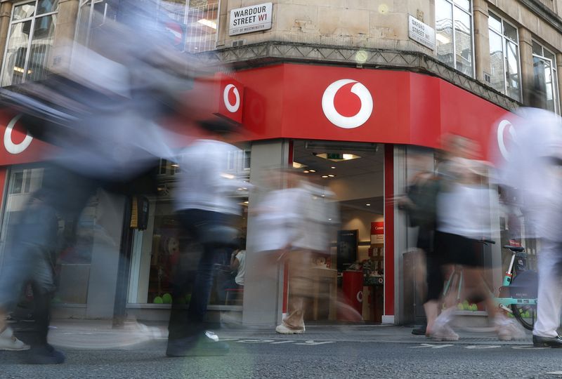 &copy; Reuters. FILE PHOTO: Shoppers walk past a Vodafone store in London, Britain, June 14, 2023. REUTERS/Toby Melville/File photo