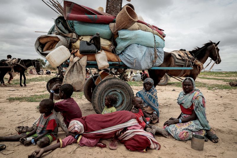 &copy; Reuters. عائلة سودانية فرت من الصراع في مورني بمنطقة دارفور بالسودان تجلس بجانب ممتلكاتها أثناء انتظار تسجيلها عند عبور الحدود بين السودان وتشاد في 